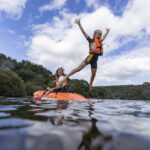 Petit garçons sautant dans l'eau d'un kayak Playa Rent avec sa maman