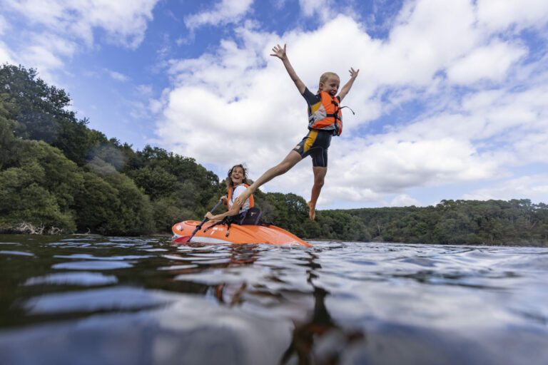 Petit garçons sautant dans l'eau d'un kayak Playa Rent avec sa maman